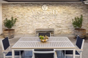 Vineyard Post Acute back patio seating area with sign on the wall